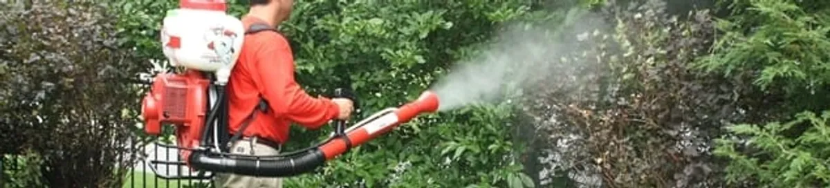 Mosquito control technician fogging shrubs and landscaping for mosquito treatment in Dayton, OH